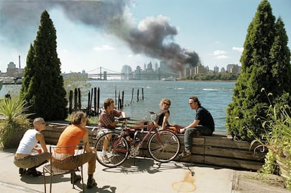 En apariencia ajenos, un grupo de jóvenes descansa en la orilla de Brooklyn del East River mientras una columna de humo asciende desde Manhattan. Es el 11 de septiembre de 2001.