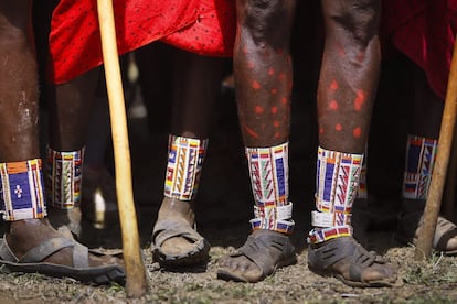 Un grupo de hombres masai jóvenes con tobilleras observan juntos la competición de salto de altura. Estos Juegos tienen como objetivo cambiar la mentalidad de los jóvenes masai, cuyas tradicional león caza ha sido un importante ritual para conmemorar su llegada a la mayoría de edad.