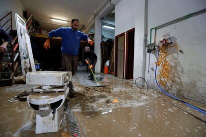 Vecinos achican agua tras las inundaciones registradas en Burlada (Navarra), este sábado. En su paso por Navarra, la crecida del Ebro puede alcanzar entre los 2.500 y los 3.200 metros cuadrados por segundo en las localidades de Castejón y Tudela, donde ya ha comenzado a provocar inundaciones durante la pasada madrugada en algunas zonas de cultivo y varias calles del casco antiguo.