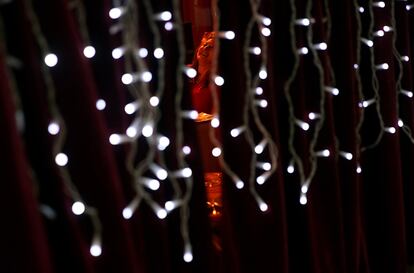 A woman laughs as she sits at the terrace of a cafe decorated with Christmas lights in Madrid, Spain, November 28, 2016. REUTERS/Susana Vera