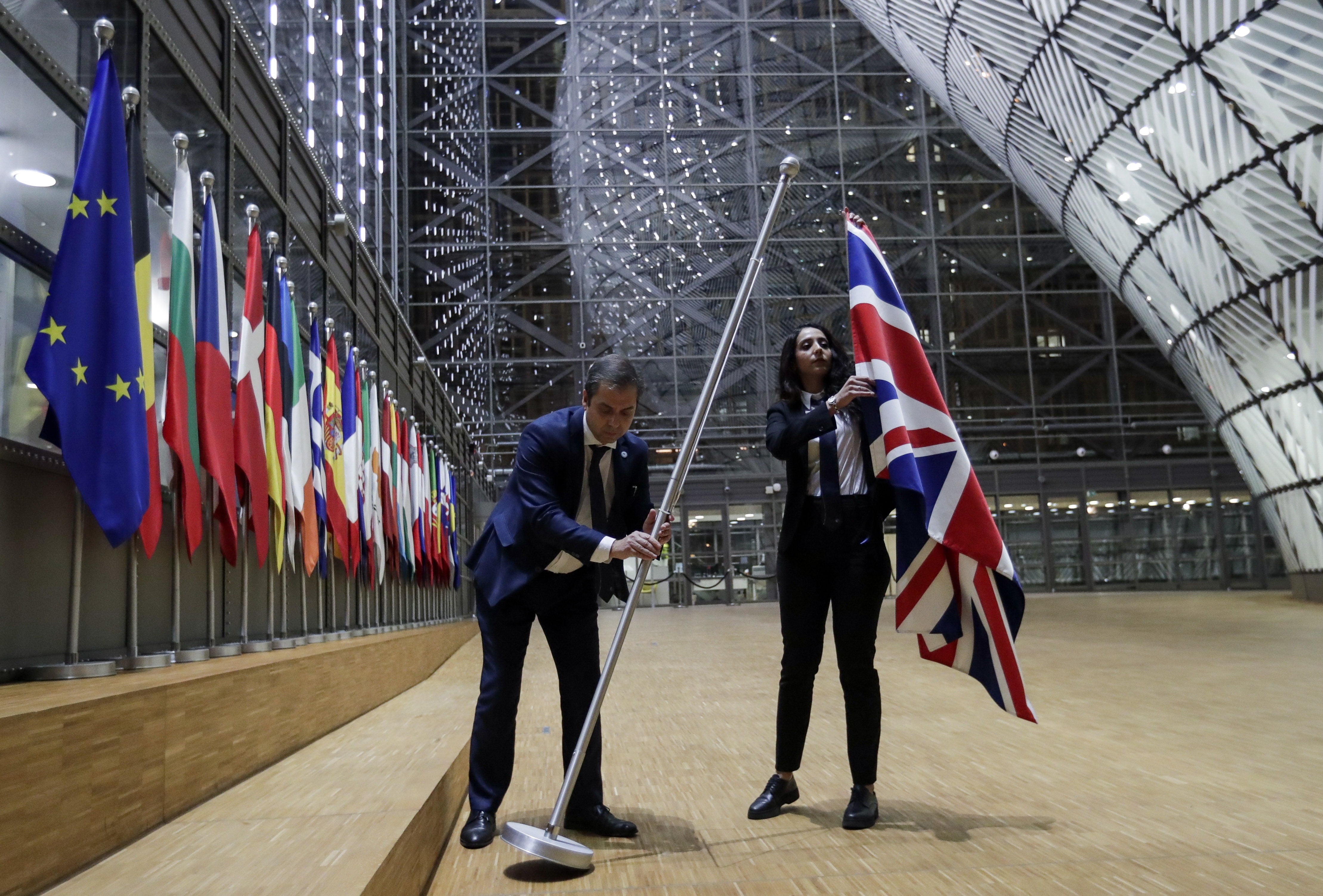 Dos funcionarios retiran la bandera del Reino Unido del Consejo Europeo, en Bruselas, el 31 de enero de 2020