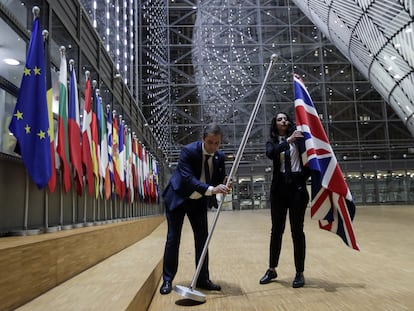 Dois funcionários retiram a bandeira britânica da sede do Conselho Europeu, nesta sexta em Bruxelas.