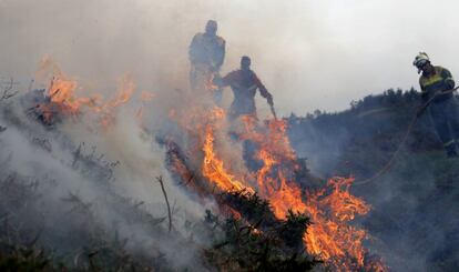 Efectius del servei de Bombers durant les tasques d'extinció de l'incendi a la parròquia de Cures, Boiro, a la serra del Barbanza.