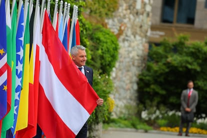 Karl Nehammer, canciller federal de Austria, posa con una bandera nacional de su país, este sábado en Stansstad (Suiza). 