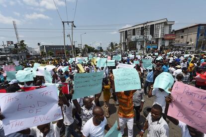 La gente grita consignas y lleva pancartas para protestar contra la suspensión de las elecciones a gobernador en Port Harcourt, estado de Rivers (Nigeria). 