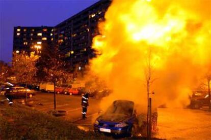 Un bombero mira el coche incendiado en un suburbio de la ciudad de Toulouse, en el sur de Francia.
