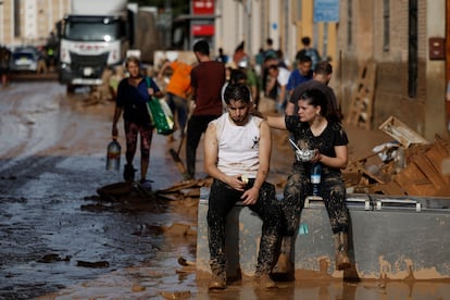 Varias personas toman algo de comida entre la desolación, en Valencia, este viernes.