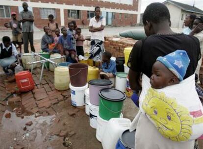 Un grupo de personas espera para recibir agua potable en Harare.