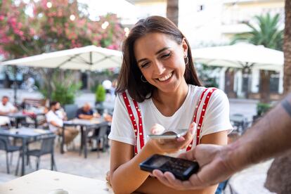 Millennial couple enjoying a coffee Espresso in a cafe. Paying the bill contactless