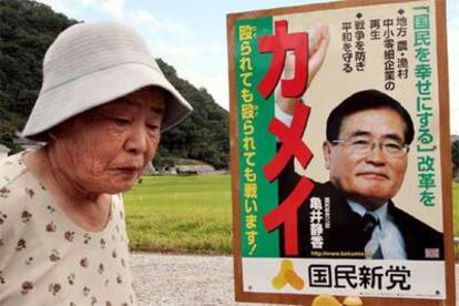 Una mujer pasa junto a un cartel electoral de Shizuka Kamei, uno de los adversarios del PLD, en Onomichi.