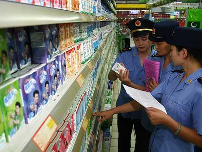 Inspectores chinos supervisan los lácteos de un supermercado.