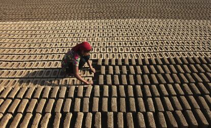 Una mujer trabaja en una fábrica de ladrillos de barro en Jammu, India.