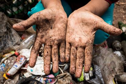 Las manos sucias de Mak Muji tras clasificar la basura delante de su casa en Bekasi, Indonesia, el 28 de septiembre de 2017. 