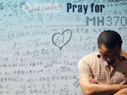 Un hombre frente a un panel con mensajes de apoyo a las v&iacute;ctimas del MH370.
 