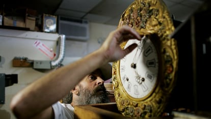 Un hombre ajusta un reloj, en una imagen de archivo.