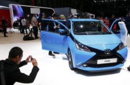 Un visitante hace una foto del Toyota Aygo en el Salón de Ginebra. Abajo el modelo C4 Cactus de Citroën.