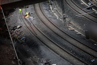 Operarios continúan trabajando en la curva donde descarriló el tren Alvia, el el pasado miércoles a pocos kilómetros de la estación de tren de Santiago de Compostela, para retirar lo que queda del convoy accidentado y el acondicionamiento de las vías, 26 de julio de 2013.