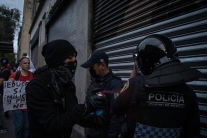 Un manifestante pinta a un agente de policía de la Ciudad de México durante la marcha.