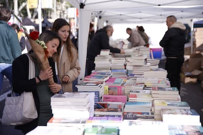 Varias personas en un puesto de libros durante el día de Sant Jordi 2024, a 23 de abril de 2024, en Barcelona (España).