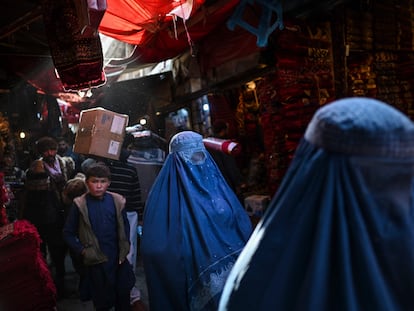 Dos mujeres con burka caminaban el domingo pasado por un mercado de alfombras en Kabul.