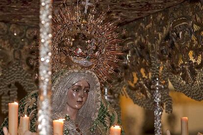 La figura de la virgen de la Esperanza atrae los objetivos de móviles y cámaras digitales durante la procesión por las calles de la capital andaluza.