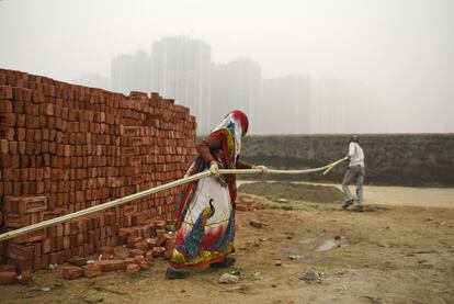 Trabajadores de la construcción bajo la niebla en Greater Noida (India). 