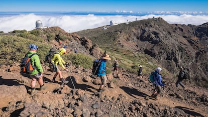 Senderistas por el parque nacional Caldera de Taburiente (con el Observatorio del Roque de los Muchachos al fondo), parte de la ruta senderista GR 131 El Bastón.