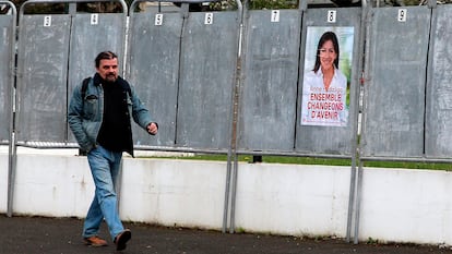 Un hombre camina junto a un cartel de campaña de la socialista Anne Hidalgo en San Juan de Luz, el 31 de marzo.