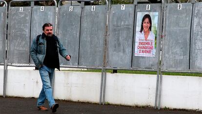 Un hombre camina junto a un cartel de campaña de la socialista Anne Hidalgo en San Juan de Luz, el 31 de marzo.