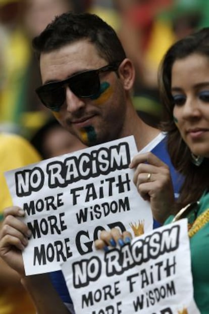 Aficionados de Brasil mostrando pancartas contra el racismo.