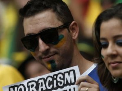 Aficionados de Brasil mostrando pancartas contra el racismo.