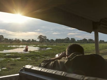 Un turista fotografía un hipopótamo durante un safari fotográfico en el delta del Okavango, en Botsuana.