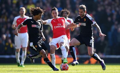 Özil controla el balón ante dos rivales del Watford.