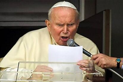 Juan Pablo II lee un saludo a los fieles durante el ángelus en la ventana de su habitación en el hospital de Roma.