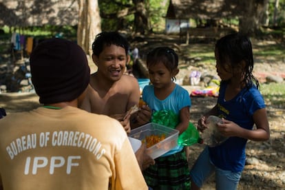 Edwin, de 46 años, vende dulces a las hijas de James Ali en la piscina natural de la prisión de Palawan. James cree que Iwahig es el comienzo de la segunda oportunidad que estos presos merecen.