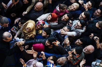 En los comicios serán elegidos los 550 miembros de la Gran Asamblea Nacional a través de un sistema de representación proporcional por listas cerradas. En la imagen, votantes saludan al presidente turco, Tayyip Erdogan, en el exterior de un centro de votación en Estambul.