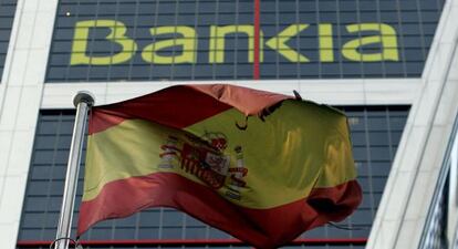 Una bandera de Espa&ntilde;a ondea ante la sede de Bankia en Madrid.