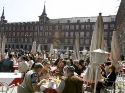 Los madrileños y los turistas aprovechan el buen tiempo de la capital para disfrutar del aperitivo y del sol en las terrazas instaladas en la Plaza Mayor. EFE/Archivo