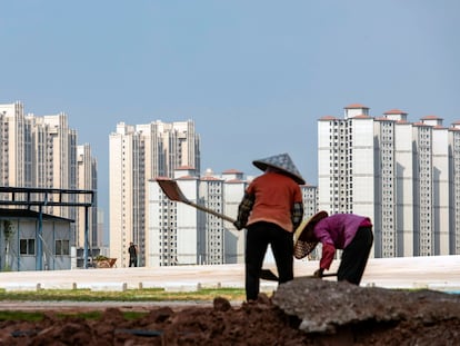 Unos trabajadores delante de unas torres en construcción, en China.