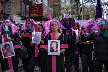 Manifestantes cargan cruces con fotografías de mujeres víctimas de feminicidio, en una protesta en 2020.