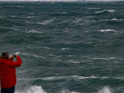 Un hombre fotografía el fuerte oleaje que azota el litoral de Muxía, en la Costa da Morte (A Coruña)