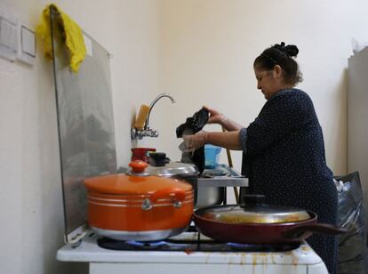 Una mujer iraquí cocina y hace su colada en la cocina de la iglesia donde se ha refugiado con su familia en Ainkawa.