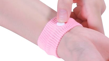 Unas manos ponindose la pulsera antimareo