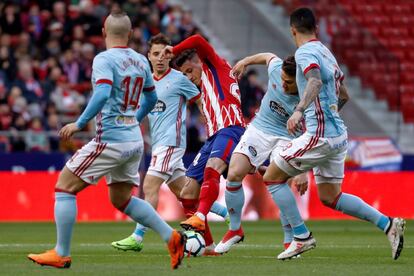 El defensa del Atlético de Madrid, José Maria Giménez, pelea el balón en medio de los jugadores del Celta de Vigo