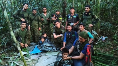 In this photo released by Colombia's Armed Forces, soldiers and Indigenous men tend to the four children who were missing after a deadly plane crash.
