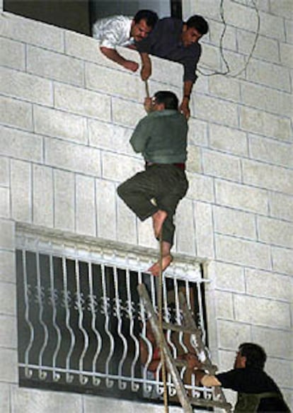 <font size="2"><b>El líder del FDLP se salva de un atentado preparado por Israel</b></font><p>En la imagen, un palestino escapa por la ventana del West Bank de Ramala tras la explosión (REUTERS).