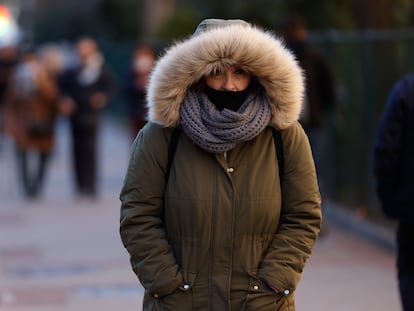Una mujer pasea muy abrigada contra el frío por Madrid, este jueves.