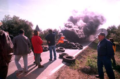 Un grupo de payeses ante una barricada de neumáticos incendiada.