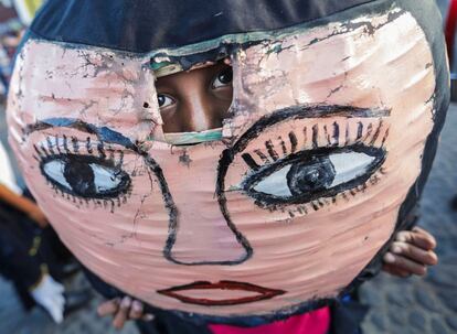 Un niño mira a través de un agujero en su máscara de "Enano Cabezón", una figura de los bailes del desfile del XIV Festival de Poesía en Granada (Nicaragua). 
