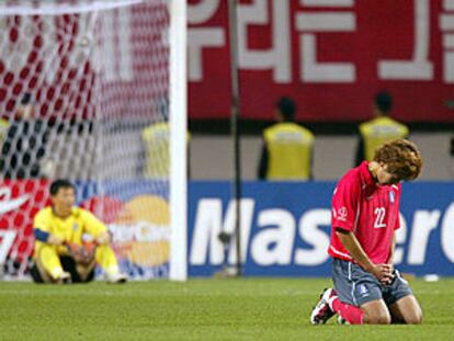 El coreano Song Chong, de rodillas, y el portero Lee Woon, sentado en el suelo, muestran su desconsuelo por la derrota de su selección.